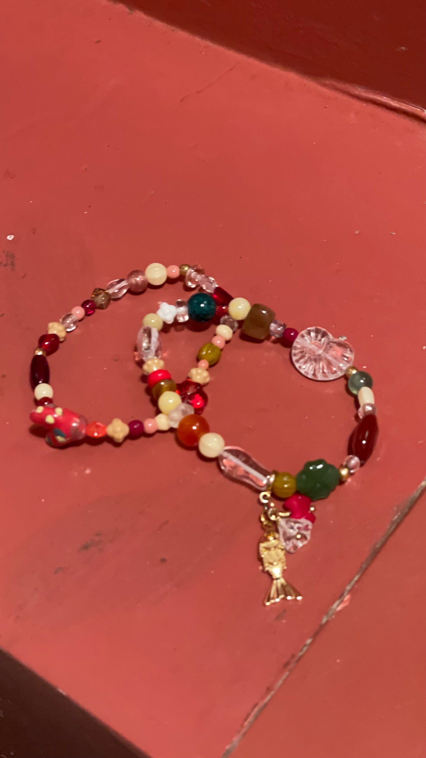 Håndlavet armbånd lavet af nøje udvalgte glas og vintageperler, med aftageligt vedhæng med metalfisk og glasperler