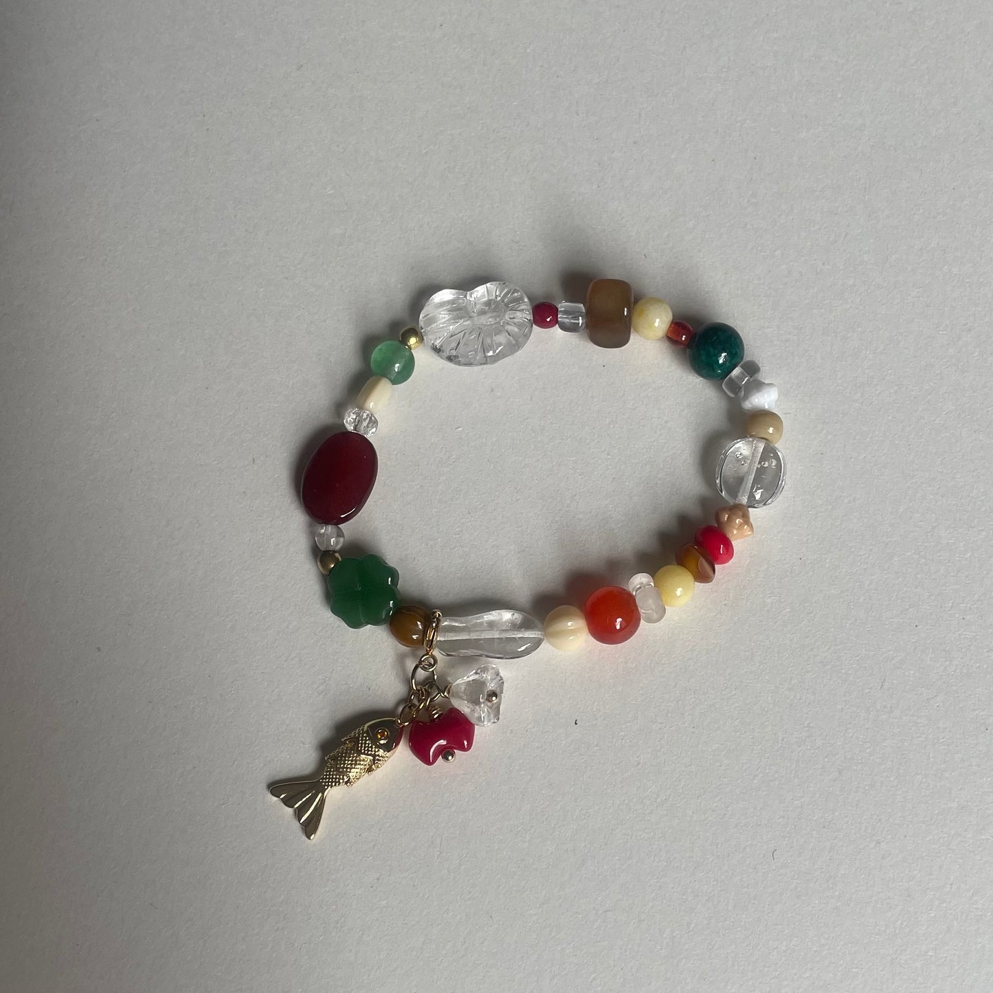 Håndlavet armbånd lavet af nøje udvalgte glas og vintageperler, med aftageligt vedhæng med metalfisk og glasperler