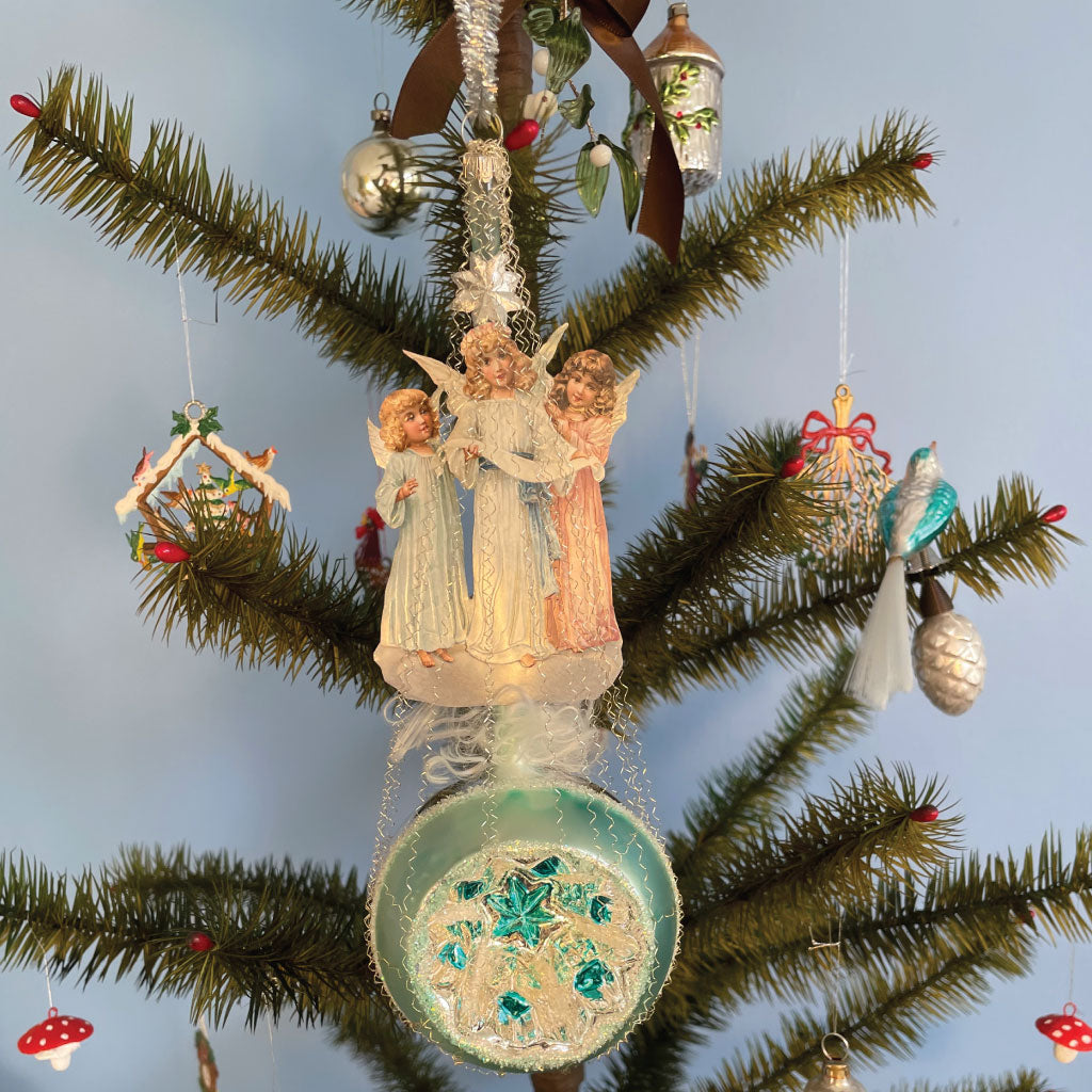 Smukt glas englekor på en lysblå reflekskugle.